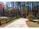 Long driveway with a stone gate and wooden fencing with a view of the lush, mature trees in the background at 355 Clark Creek Pass, Acworth, GA 30102