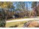 An outbuilding nestled amongst mature trees, including a shed-roofed chicken coop, is visible from the driveway at 355 Clark Creek Pass, Acworth, GA 30102