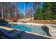 Stunning pool and spa area with lounge chairs, surrounded by a wooden fence and greenery at 355 Clark Creek Pass, Acworth, GA 30102