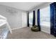Light-filled bedroom with bunk beds, playful dinosaur curtains, light gray walls, and a cozy beanbag chair at 180 Paula Dr, Tyrone, GA 30290