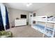 Shared bedroom with a bunk bed, light walls, neutral carpet, and decorative dinosaur-themed curtains at 180 Paula Dr, Tyrone, GA 30290