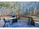 Wooden deck with dining table and chairs overlooking large yard with mature trees at 180 Paula Dr, Tyrone, GA 30290