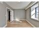Well-lit bedroom with grey walls, wood-look floors, and open door at 1900 Mornington Ln, Snellville, GA 30078