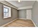 Grey walls, wood-look floors, and a window in this bright bedroom at 1900 Mornington Ln, Snellville, GA 30078