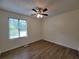 Bright bedroom with laminate flooring, a ceiling fan and a large window providing ample natural light at 3648 E Melissa Ln, Douglasville, GA 30135