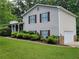 Side view of a split-level home featuring vinyl siding, an attached garage, and manicured landscaping at 3648 E Melissa Ln, Douglasville, GA 30135