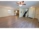 Open-concept living space with new laminate flooring, ceiling fan, and view of the kitchen and staircase at 3648 E Melissa Ln, Douglasville, GA 30135