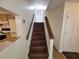 Interior view of wood staircase featuring wooden handrails and a bright landing with a view into the kitchen at 3648 E Melissa Ln, Douglasville, GA 30135