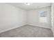 Spacious bedroom with grey carpet, neutral walls, and a window at 4745 Marjorie Dr, Cumming, GA 30041