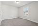 Simple bedroom with grey carpet, neutral walls, and a window at 4745 Marjorie Dr, Cumming, GA 30041
