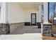Covered front porch with gray stone columns and a black front door at 4745 Marjorie Dr, Cumming, GA 30041