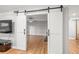 Interior view of open white barn doors accessing living room space at 6851 Roswell Rd # I18, Sandy Springs, GA 30328