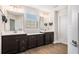 Bathroom featuring a double vanity with dark cabinets and modern fixtures, complemented by wood-look flooring at 467 Daffodil Ln, Mcdonough, GA 30253