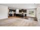 Open-concept kitchen with dark cabinets, a large island, and hardwood floors, seamlessly connecting living spaces at 467 Daffodil Ln, Mcdonough, GA 30253