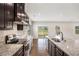 Elegant kitchen featuring dark wood cabinets, granite countertops, stainless appliances, and modern fixtures at 467 Daffodil Ln, Mcdonough, GA 30253