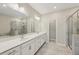 A spacious bathroom with double sinks, quartz countertops and tile flooring at 4145 Essex Pond Way, Cumming, GA 30040