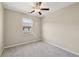 This is a cozy carpeted bedroom with neutral walls, ceiling fan, and a window with neighborhood views at 4145 Essex Pond Way, Cumming, GA 30040