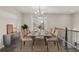 Elegant dining room offering a modern table set, chandelier, and staircase views at 4145 Essex Pond Way, Cumming, GA 30040