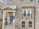 Detailed view of the townhome entrance with charming front porch, balcony, and well-maintained landscaping at 4145 Essex Pond Way, Cumming, GA 30040