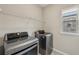 This laundry room features modern LG washer and dryer, plus convenient overhead shelving and a bright window at 4145 Essex Pond Way, Cumming, GA 30040