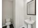 A powder room featuring a pedestal sink and dark wood look floors at 4145 Essex Pond Way, Cumming, GA 30040