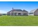 Rear of a house featuring a covered porch, dark siding and a large manicured lawn at 101 Red Oak Ln, Carrollton, GA 30116
