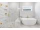Spa-like bathroom showcasing a soaking tub, glass shower, and gold fixtures, complemented by elegant tile work at 101 Red Oak Ln, Carrollton, GA 30116