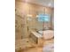 Modern bathroom with a glass-enclosed shower, soaking tub, and marble-tiled walls for a spa-like experience at 101 Red Oak Ln, Carrollton, GA 30116