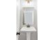 A stylish pedestal sink and vanity are illuminated by modern lighting in this well-appointed powder room at 101 Red Oak Ln, Carrollton, GA 30116