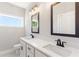Bathroom featuring double sinks, quartz countertop, black framed mirrors, and modern lighting fixtures at 101 Red Oak Ln, Carrollton, GA 30116