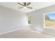 Bright bedroom featuring a ceiling fan, neutral walls, carpet, and natural light from the multiple windows at 101 Red Oak Ln, Carrollton, GA 30116