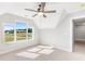 Bright bedroom featuring a ceiling fan, neutral walls, carpet, and natural light from the multiple windows at 101 Red Oak Ln, Carrollton, GA 30116