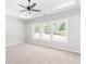 A spacious bedroom with neutral walls, three large windows, carpeted floor, and a ceiling fan at 101 Red Oak Ln, Carrollton, GA 30116