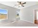 Bright bedroom featuring plush carpet, ceiling fan and natural light from two large windows at 101 Red Oak Ln, Carrollton, GA 30116