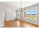 Bright dining room with large windows, hardwood floors, and a modern chandelier, ideal for Gathering meals at 101 Red Oak Ln, Carrollton, GA 30116
