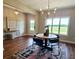 Dining room with a round table, black chairs, hardwood floors, view from a large window and a modern light fixture at 101 Red Oak Ln, Carrollton, GA 30116