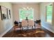 Bright dining room featuring a modern table setting, stylish chairs, hardwood floors, and natural light from two large windows at 101 Red Oak Ln, Carrollton, GA 30116