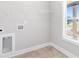 A bright laundry room with tile floor, laundry hookups, shelving, and window with nice view at 101 Red Oak Ln, Carrollton, GA 30116