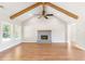 Spacious living room featuring a vaulted ceiling, wood beams, modern fireplace, and ample natural light at 101 Red Oak Ln, Carrollton, GA 30116