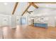 Bright, open-concept living area featuring hardwood floors, vaulted ceilings with beams, and a modern kitchen with blue accents at 101 Red Oak Ln, Carrollton, GA 30116
