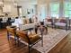 Open-concept living room featuring hardwood floors, stylish furniture, and a view into the kitchen and dining area at 101 Red Oak Ln, Carrollton, GA 30116