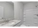Bright bathroom featuring a granite countertop, undermount sink, and a shower with built-in shelves at 620 Egrets Landing Lot #68 Lndg, Covington, GA 30014