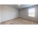 A bright bedroom with neutral walls, carpeted flooring, and a large window offering natural light at 620 Egrets Landing Lot #68 Lndg, Covington, GA 30014