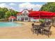 Relaxing pool area featuring a mushroom fountain, tables with red umbrellas, and a charming clubhouse at 620 Egrets Landing Lot #68 Lndg, Covington, GA 30014