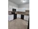 Spacious kitchen features white cabinets, black appliances, and tile floors at 2438 Brianna Dr, Hampton, GA 30228