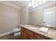 Bathroom featuring granite counters, wood cabinets, a white toilet, and a large mirror at 6191 Talmadge Run, Acworth, GA 30101