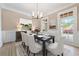 Formal dining room with large windows, a dark wood table, and seating for six at 6191 Talmadge Run, Acworth, GA 30101