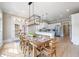 Dining room featuring a long wooden table, an elegant chandelier, and a view of the modern kitchen at 6191 Talmadge Run, Acworth, GA 30101