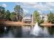 Stunning waterfront home with a fountain, trees, and lush landscaping at 6191 Talmadge Run, Acworth, GA 30101