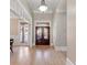 Elegant foyer with wood floors, a beautiful chandelier, and a decorative wood and glass front door at 6191 Talmadge Run, Acworth, GA 30101